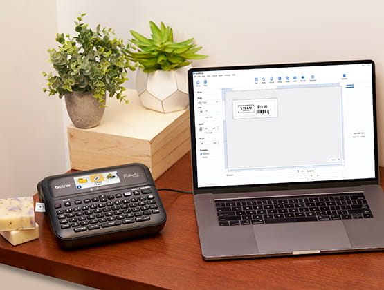 Laptop connected to PT-D610BT label maker for printing on desk with plants in background