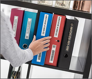 Person selecting binder with a Ptouch label from a shelf