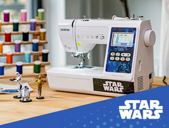 Star Wars LB5000S computerized sewing and embroidery machine in a craf troom with R2D2, C3PO and Storm Trooper action figures next to machine.